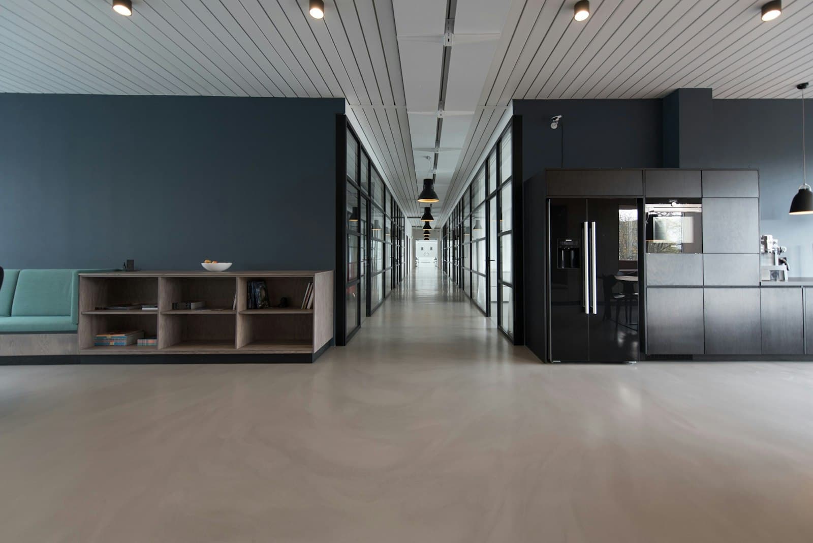 Office studio with a deep-blue end wall and otherwise quiet, light walls.