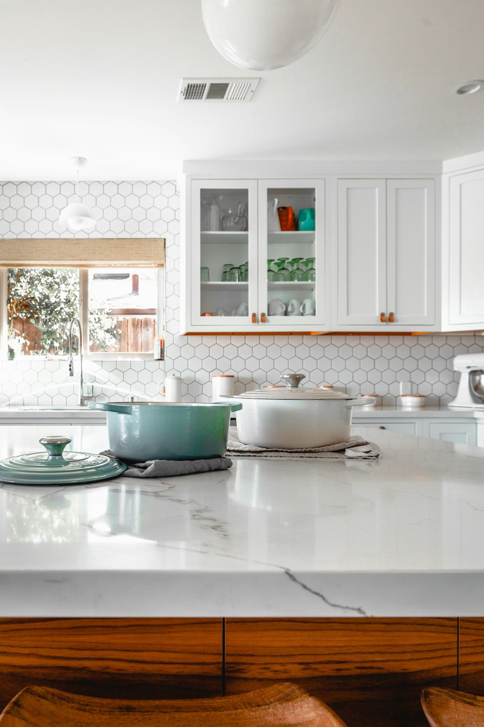 Bright kitchen with stone-white walls, a marble worktop and composed transitions into timber.